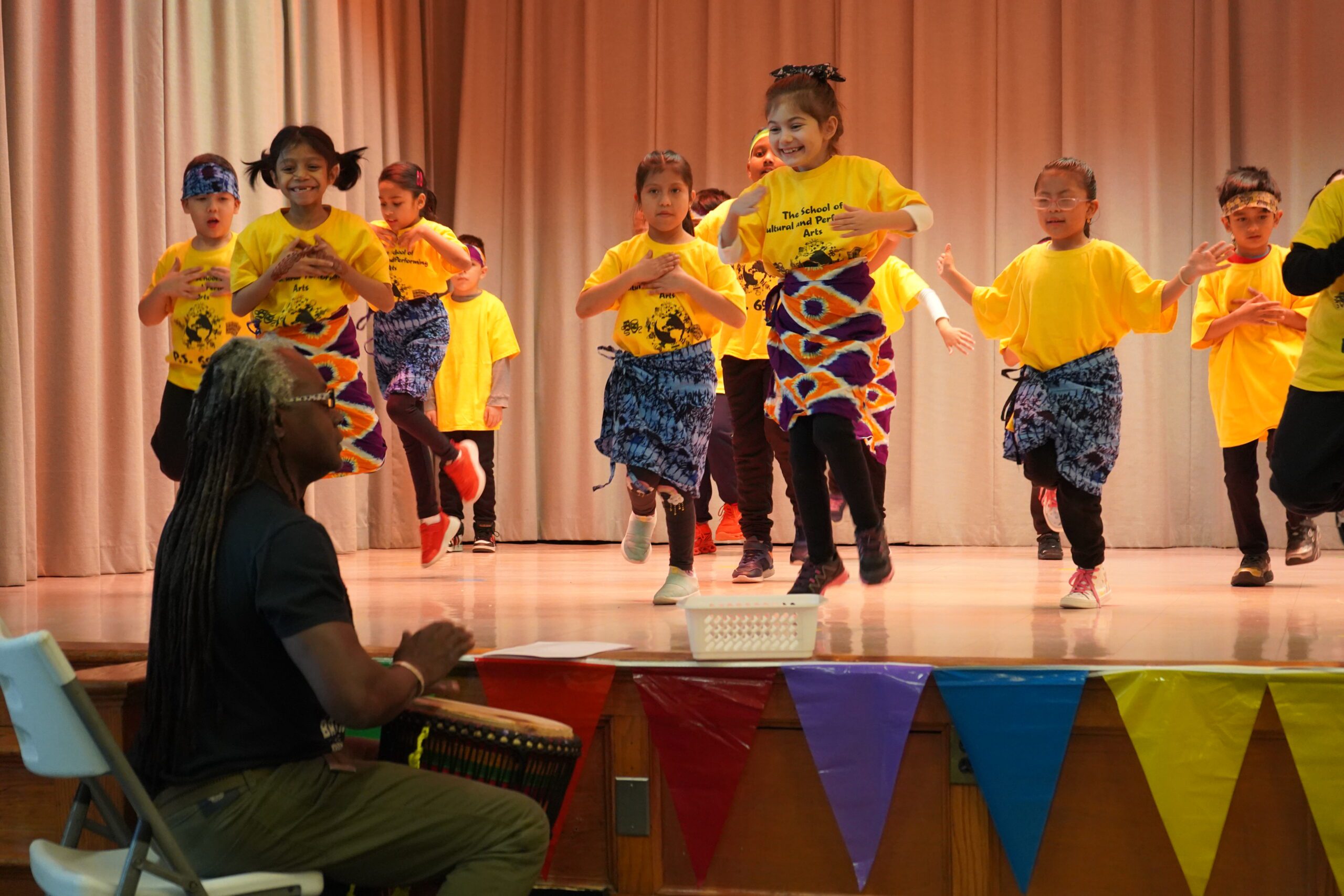 Students perform for their culminating show at PS69 while Yahaya drums!